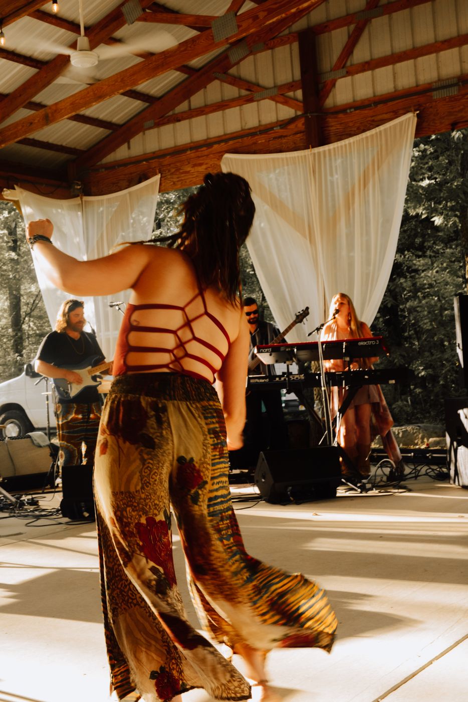 A dancer moving in front of the stage under the pavilion